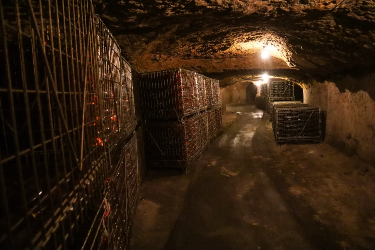 Bouteilles en vieillissement sur lattes dans la cave troglodytique de Vouvray